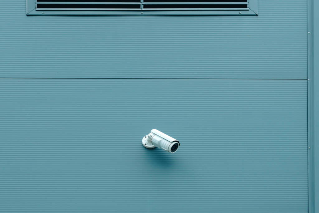 Outdoor surveillance security camera mounted on industrial building wall